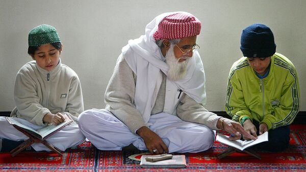 An Iman helps a young boy learn The Koran at The Central Mosque in Luton - Sputnik International