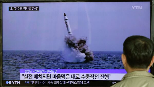 A South Korean man watches a TV news program showing an image published in North Korea's Rodong Sinmun newspaper of North Korea's ballistic missile believed to have been launched from underwater, at Seoul Railway station in Seoul, South Korea, Saturday, May 9, 2015 - Sputnik International