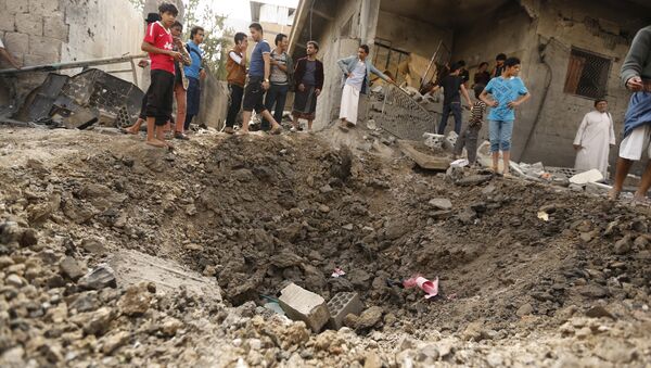 People gather at a site hit by a Saudi-led air strike in Yemen's capital Sanaa May 27, 2015 - Sputnik International