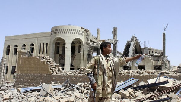 Houthi militant stands in front of a court building, which was damaged in a Saudi-led air strike in Saada May 31, 2015 - Sputnik International