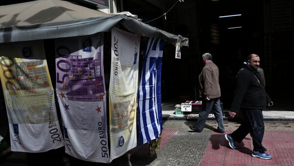 People walk past towels depicting Euro banknotes hanging outside a kiosk in Athens on March 22, 2015 - Sputnik International