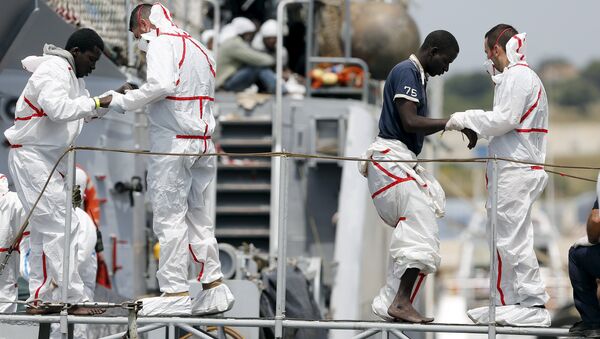 Migrants are helped to disembark from Italian Navy vessel Fenice as they arrive in the Sicilian harbour of Augusta, Italy, May 31, 2015 - Sputnik International