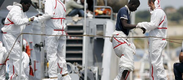 Migrants are helped to disembark from Italian Navy vessel Fenice as they arrive in the Sicilian harbour of Augusta, Italy, May 31, 2015 - Sputnik International