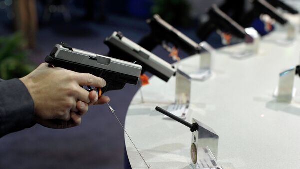 A firearms retailer examines a Smith & Wesson 9mm pistol at the Shooting, Hunting and Outdoor Trade show, Jan. 18, 2011, in Las Vegas - Sputnik International