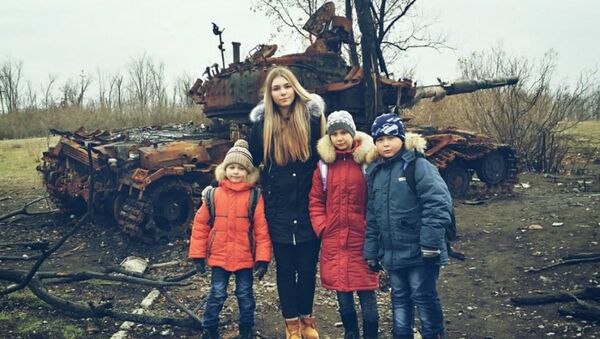 Powerlifting Champion Maryana Naumova poses with local children on a humanitarian trip to Luhansk. - Sputnik International