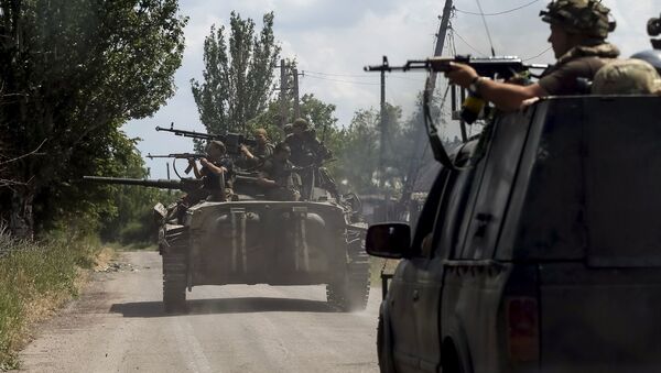Members of the Ukrainian armed forces ride on an armoured personnel carrier as they patrol the area in the town of Maryinka, eastern Ukraine, June 5, 2015 - Sputnik International