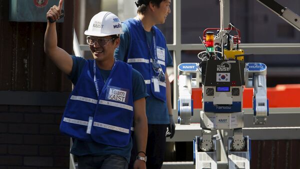 A member of Team KAIST DRC-Hubo celebrates after completing their run in the finals of the Defense Advanced Research Projects Agency (DARPA) Robotic Challenge in Pomona, California June 6, 2015. - Sputnik International