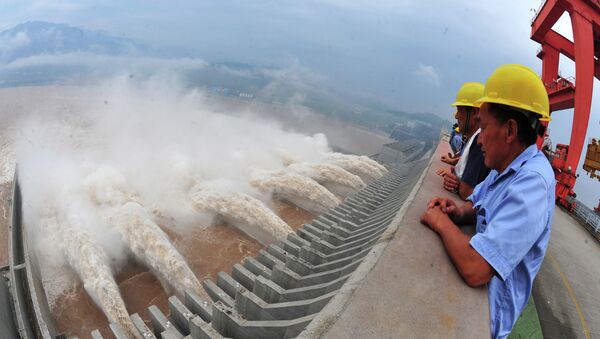 This picture taken on July 24, 2012 shows workers watching as water is released from the Three Gorges Dam, a gigantic hydropower project on the Yangtze river, in Yichang, central China's Hubei province - Sputnik International