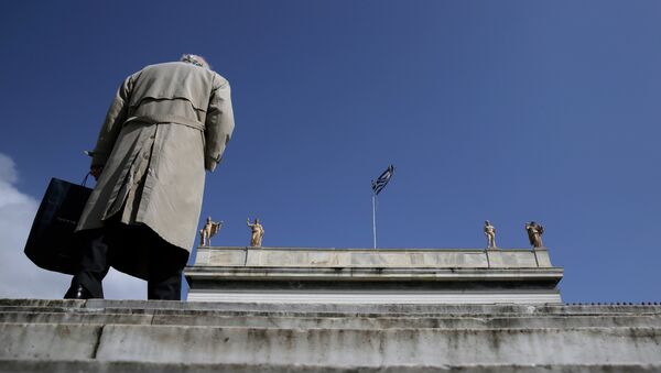 A pedestrian walks past statues, which stand at the top of the National Archaeological Museum of Greece as a Greek flag flies in central Athens - Sputnik International