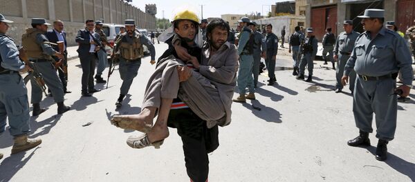 An Afghan policeman carries an injured man after an attack in Kabul, Afghanistan in this May 17, 2015 file photo An Afghan policeman carries an injured man after an attack in Kabul, Afghanistan in this May 17, 2015 file photo - Sputnik International