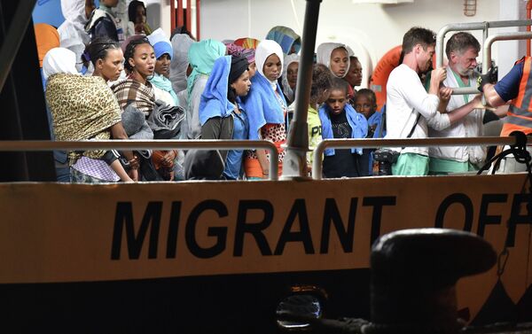 Migrants wait to disembark from the Migrant Offshore Aid Station (MOAS) ship Phoenix in the Sicilian port town of Augusta, Italy, Sunday, June 7, 2015 - Sputnik International