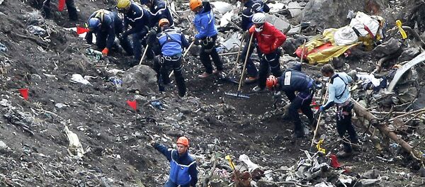 In this March 26, 2015 file photo, rescue workers work on debris of the Germanwings jet at the crash site near Seyne-les-Alpes, France - Sputnik International