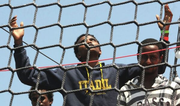 A migrant opens his arms as he waits to disembark from the German Navy ship Hessen at the Palermo harbor, Italy. A migrant opens his arms as he waits to disembark from the German Navy ship Hessen at the Palermo harbor, Italy. - Sputnik International