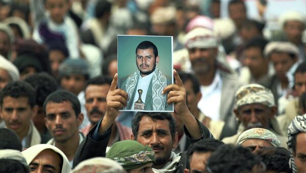 A Yemeni Shiite man holds up a picture of the Shiite movement leader Abdul-Malik al-Houthi during a demonstration organized by the Shiite Huthi movement to demand the government to rescind a decision to curb fuel subsidies on August 20, 2014 - Sputnik International