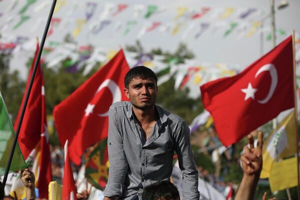 Backdropped by Turkish flags a supporter of Kurdish People’s Democratic Party (DHP) attends a rally in Diyarbakir, southeastern Turkey. - Sputnik International