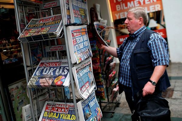 A man reads a newspaper at a kiosk, featuring front-page coverage of Sunday's elections, in Istanbul, Turkey, Monday, June 8, 2015. - Sputnik International