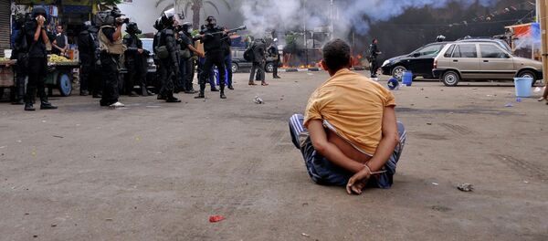 A handcuffed protester sits on the ground as Egyptian security forces move in to disperse supporters of Egypt's ousted president Mohamed Morsi by force in a huge camp in Cairo's Al-Nahda square on August 14, 2013 A handcuffed protester sits on the ground as Egyptian security forces move in to disperse supporters of Egypt's ousted president Mohamed Morsi by force in a huge camp in Cairo's Al-Nahda square on August 14, 2013 - Sputnik International