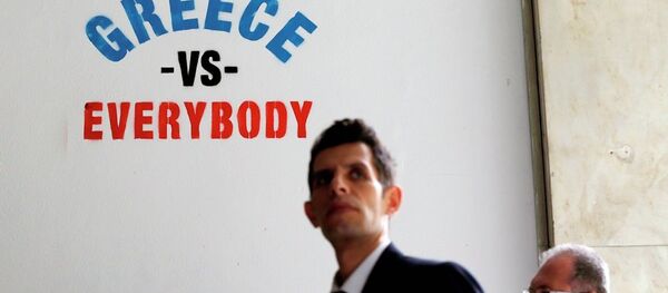 Pedestrians walk past stenciled graffiti on a wall outside of a bank in Athens. Pedestrians walk past stenciled graffiti on a wall outside of a bank in Athens. - Sputnik International