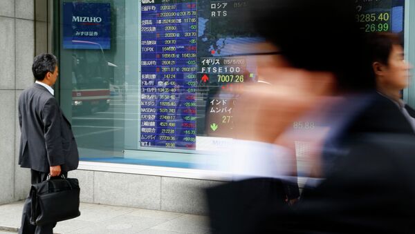 A man looks at an electronic stock indicator of a securities firm in Tokyo, Thursday, May 21, 2015 - Sputnik International