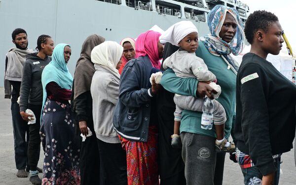 Migrants disembark from the Royal Navy ship HMS Bulwark upon their arrival in the port of Catania on the coast of Sicily on June 8, 2015 - Sputnik International