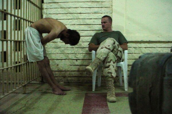 This is an image obtained by The Associated Press which shows a detainee bent over with his hands on the bars of a prison cell watched by a soldier in late 2003 at the Abu Ghraib prison in Baghdad, Iraq This is an image obtained by The Associated Press which shows a detainee bent over with his hands on the bars of a prison cell watched by a soldier in late 2003 at the Abu Ghraib prison in Baghdad, Iraq - Sputnik International