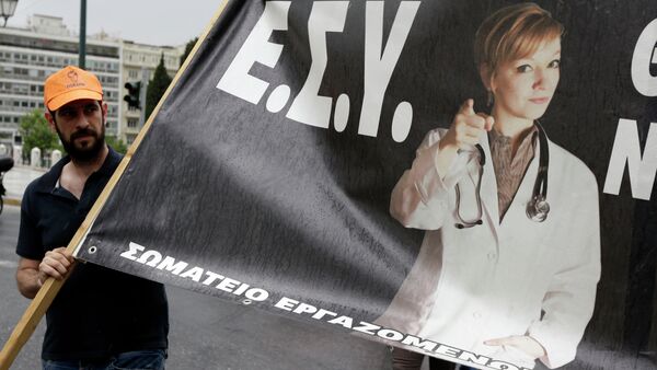 A health worker holds a banner that reads National Health System (E.S.Y.) during a strike protesting understaffing and underfunding and demanding back pay in Athens, Wednesday, May 20, 2015 - Sputnik International