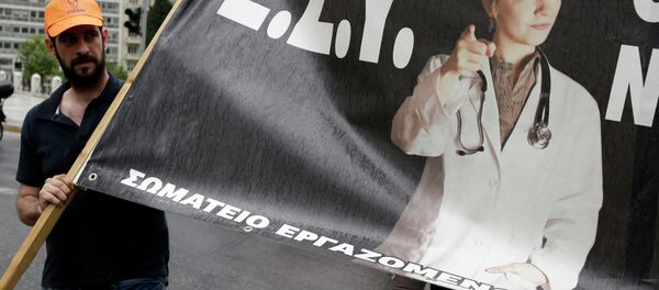 A health worker holds a banner that reads National Health System (E.S.Y.) during a strike protesting understaffing and underfunding and demanding back pay in Athens, Wednesday, May 20, 2015 A health worker holds a banner that reads National Health System (E.S.Y.) during a strike protesting understaffing and underfunding and demanding back pay in Athens, Wednesday, May 20, 2015 - Sputnik International
