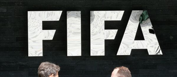 Two men talk to each other in front of the FIFA logo at the FIFA headquarters in Zurich, Switzerland, Wednesday, May 27, 2015 - Sputnik International