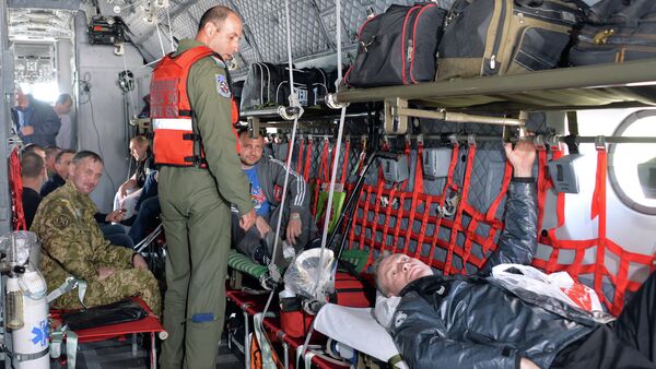Medical personnel from the Romanian military take wounded Ukrainian soldiers on board a Romanian medical military plane at Kiev's Boryspil International Airport on April 29, 2015 - Sputnik International