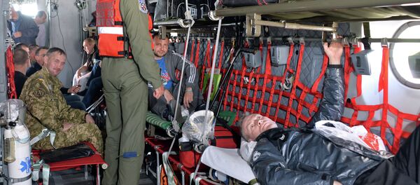 Medical personnel from the Romanian military take wounded Ukrainian soldiers on board a Romanian medical military plane at Kiev's Boryspil International Airport on April 29, 2015 Medical personnel from the Romanian military take wounded Ukrainian soldiers on board a Romanian medical military plane at Kiev's Boryspil International Airport on April 29, 2015 - Sputnik International