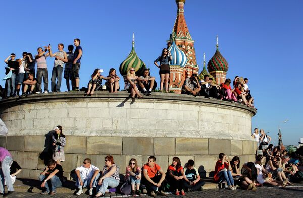 People sit at the Lobnoye Mesto, also known as the Place of Skulls, at Red Square enjoying a sunny day in downtown Moscow, Russia, Sunday, June 12, 2011 - Sputnik International
