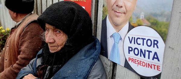 An elderly woman, back dropped by a campaign poster of Romanian Prime Minister Victor Ponta in 2011. - Sputnik International