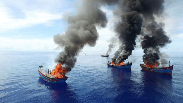 Columns of black smoke rise from four Vietnamese boats in the waters off Palau. - Sputnik International