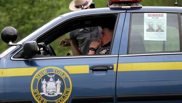 A wanted poster is displayed in the window of a state police officer's car near Dannemora, N.Y - Sputnik International