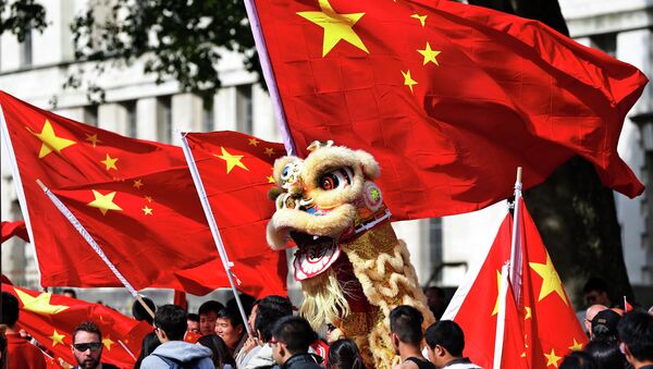 Chinese students hold a puppet depicting a dragon and  wave their national flags - Sputnik International