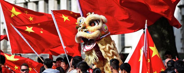 Chinese students hold a puppet depicting a dragon and  wave their national flags - Sputnik International