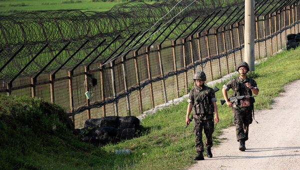 In this June 30, 2014 file photo, South Korean army soldiers patrol through the military wire fence in Paju, near the border with North Korea, South Korea - Sputnik International