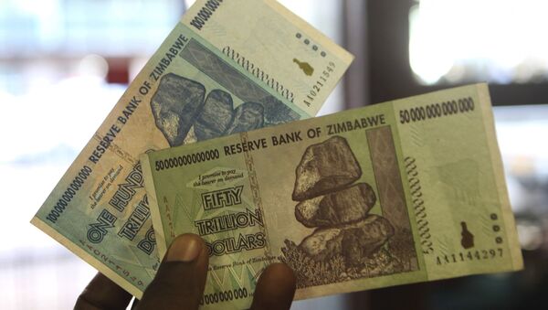 A man holds up for a picture a one hundred and an a fifty trillion Zimbabwean dollars notes inside a shop in Harare, Zimbawe, June 12, 2015 - Sputnik International