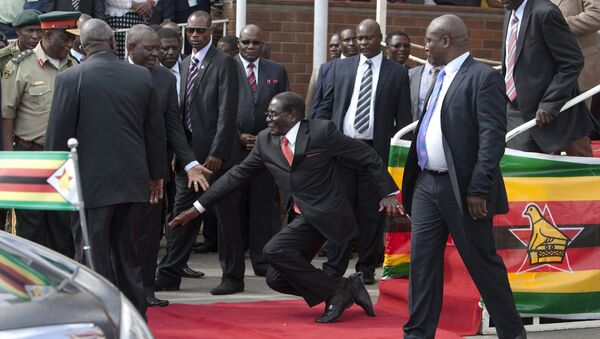 Zimbabwean President Robert Mugabe, center, falls after addressing supporters upon his return from an African Union meeting in Ethiopia, Wednesday, Feb. 4, 2015 - Sputnik International