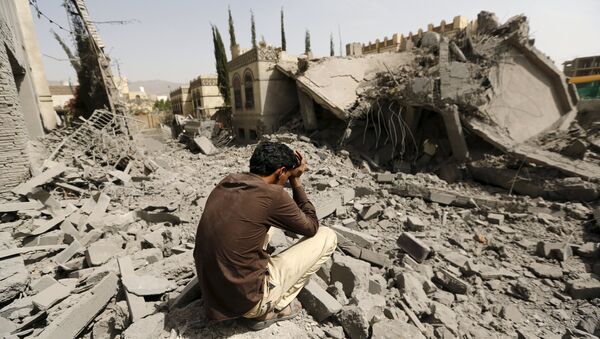 A guard sits on the rubble of the house of Brigadier Fouad al-Emad, an army commander loyal to the Houthis, after air strikes destroyed it in Sanaa, Yemen June 15, 2015 - Sputnik International
