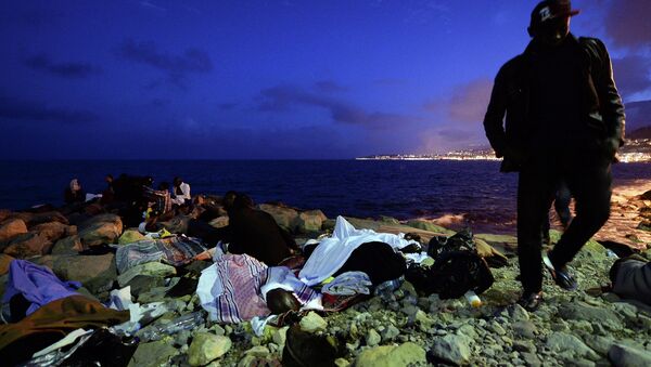 Migrants sleep on the rocks by the sea in Ventimiglia, at the border between Italy and France, early Monday, June 15, 2015 - Sputnik International