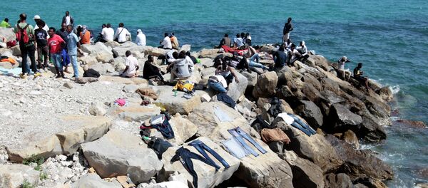 Migrants dry their clothes on rocks as they wait to cross into France, in the Italian city of Ventimiglia, on the French-Italian border, on June 14, 2015 - Sputnik International