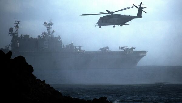 A CH-53E Super Stallion helicopter flies ahead of the amphibious assault ship USS Peleliu off the coast of Hawaii during Rim of the Pacific exercise in 2014. - Sputnik International