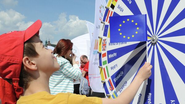 A boy holding a EU flag looks at a wheel with the names of all European Union countries during a picnic marking ten years since Poland joined the EU, in Warsaw, Poland, Thursday, May 1, 2014 - Sputnik International