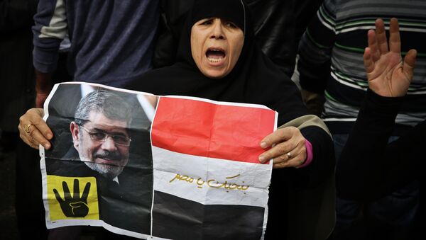 A supporter of the Muslim Brotherhood movement holds a placard showing ousted president Mohamed Morsi during a demonstration on January 24, 2015 in the Cairo district of Heliopolis (photo used for illustration purpose only)) - Sputnik International
