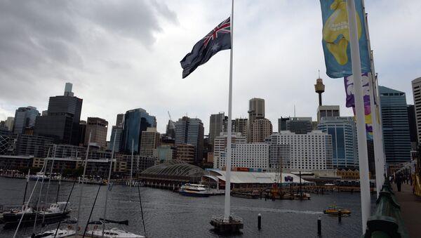 An Australian national flag flies in front of the city skyline at the Darling Harbour in Sydney on July 19, 2014 - Sputnik International