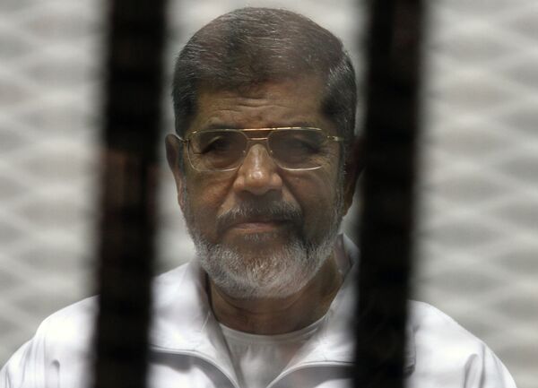 Egyptian ousted Islamist president Mohamed Morsi looks on from behind the defendants cage during is trial on May 8, 2014 - Sputnik International