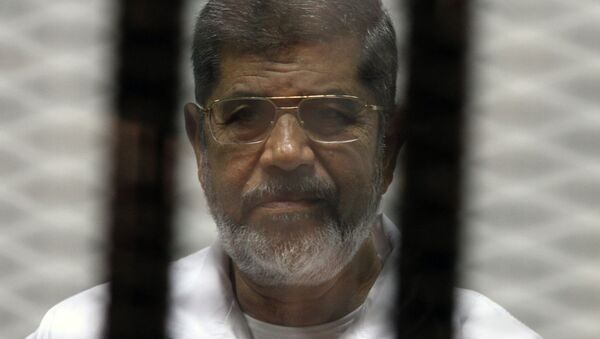 Egyptian ousted Islamist president Mohamed Morsi looks on from behind the defendants cage during is trial on May 8, 2014 - Sputnik International