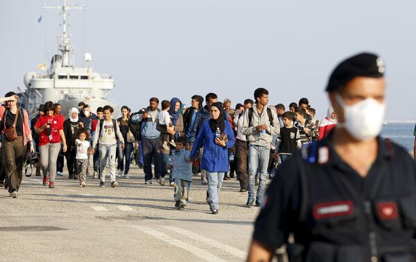Syrian refugees are escorted by Carabinieri after disembarking from Belgian Navy vessel Godetia at the Augusta port, Italy, June 10, 2015 - Sputnik International