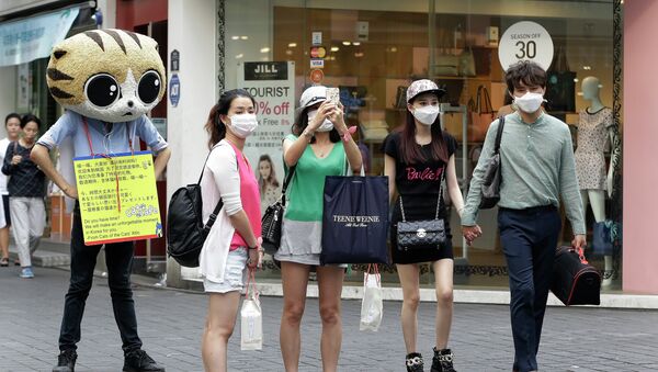 People wear masks as a precaution against the MERS virus as they walk in Myeongdong, one of Seoul's main shopping districts. - Sputnik International
